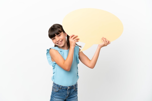 Little caucasian kid isolated on white background holding an empty speech bubble