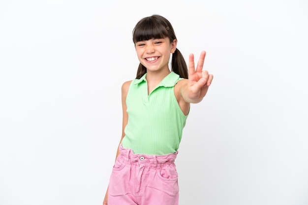 Little caucasian kid isolated on white background smiling and showing victory sign