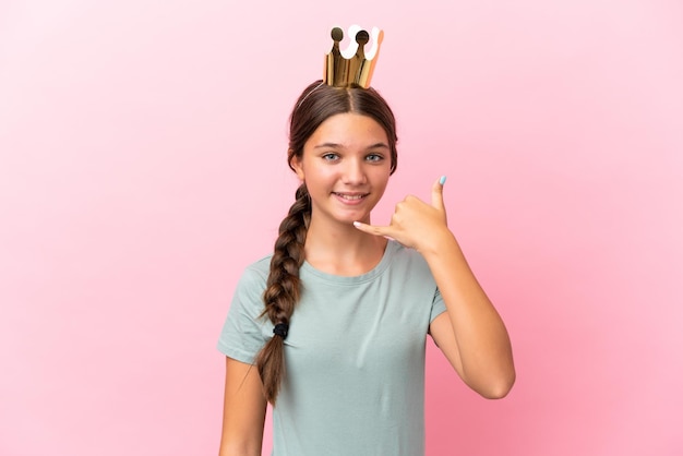 Little caucasian princess girl isolated on pink background making phone gesture Call me back sign