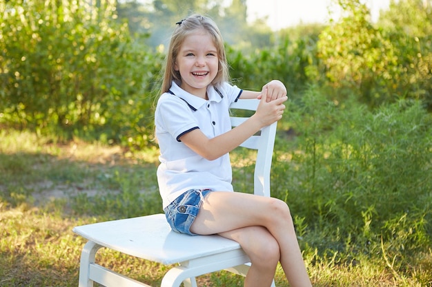 Little charming girl in the summer garden