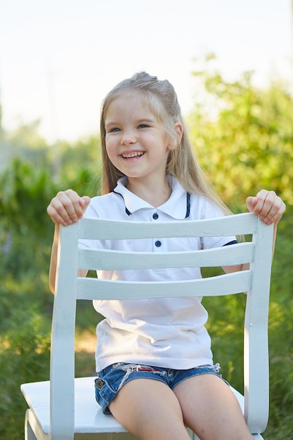 Little charming girl in the summer garden