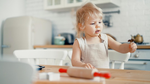 The little chef is the host on the table with the ingredients flour and sugar for a cake or sweet