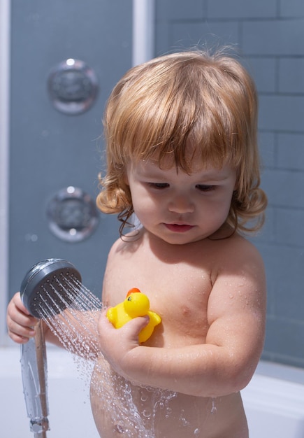 Little child bathing in soapsuds washing adorable baby in bathroom kid with soap suds on hair taking...