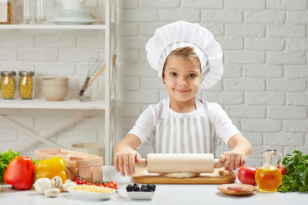 Little child boy in cap and an apron cook