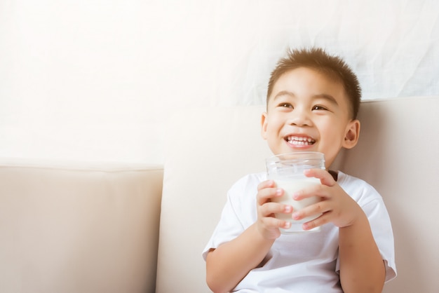 Little child boy hand holding milk glass he drinking white milk