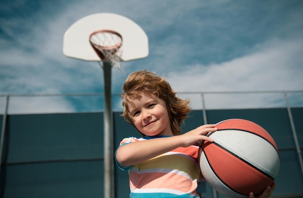 Little child boy playing basketball with basket ball