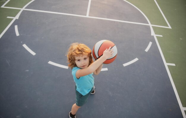 Little child boy playing basketball with basket ball