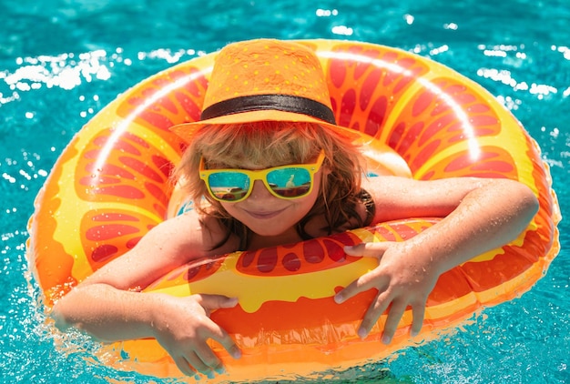 부풀릴 수 있는 장난감 반지가 있는 수영장에 있는 어린 소년 어린이 여름 휴가는 어린이 o를 위해 수영합니다.