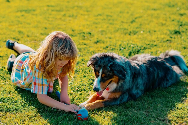 Photo little child boy with pet dog outdooors in park