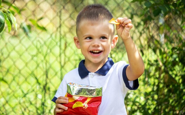 Little child eats potato chips.