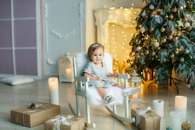 Little child girl next to boxes wrapped by gray paper