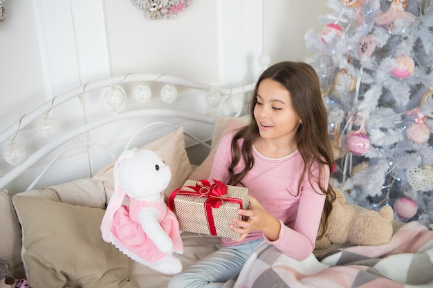 Little child girl likes xmas present the morning before xmas\
new year holiday christmas kid enjoy the holiday happy new year\
small happy girl at christmas wishing a happy new year