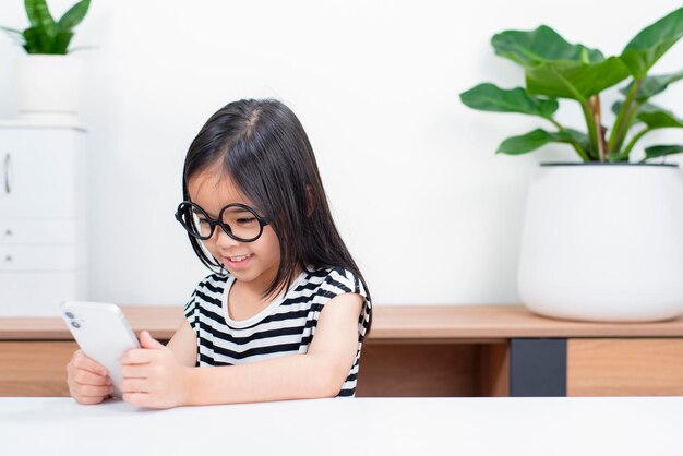 Little child girl play on smartphone at home