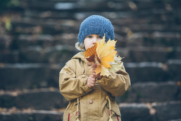 Bambina bambino in giacca calda e cappello in autunno nel parco