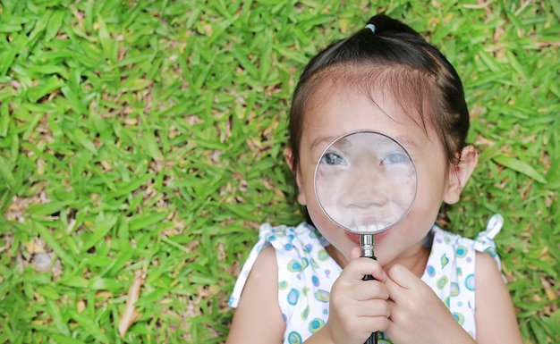 Little child girl with a magnifying glass 