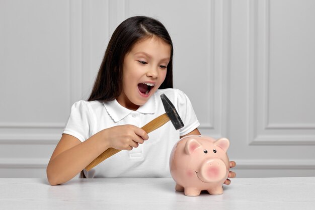 Little Child Girl With Piggy Bank At Home