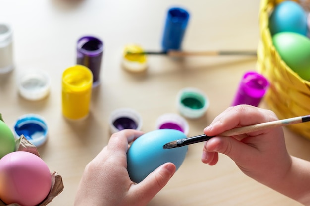 Little child hands painting colored eggs easter family holiday at home and craft concept