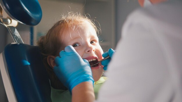 Фото Маленький ребенок в стоматологическом кресле - крупным планом