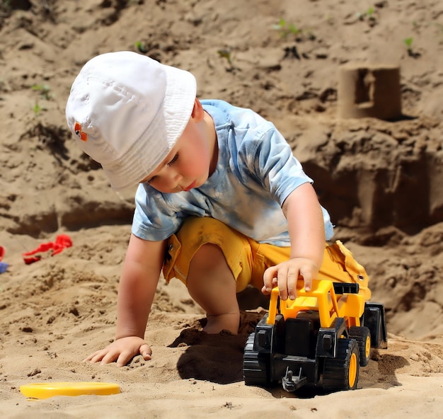 Маленький ребенок играет с песком