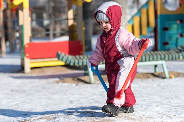Маленький ребенок играет на улице зимой