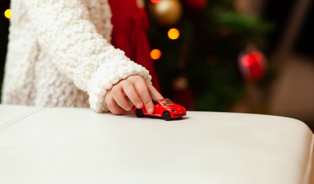 Little child plays with little toy car.