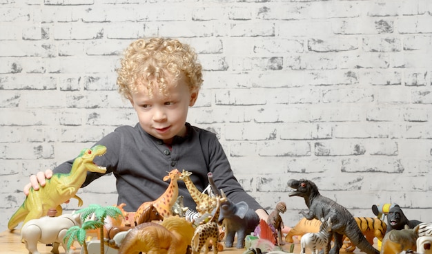 A little child plays with toys animals