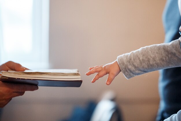 Un bambino piccolo tira la mano verso la bibbia