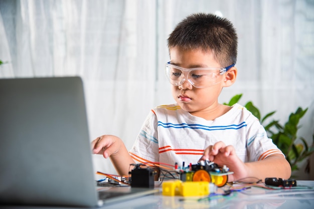 Little child trying assemble build wheel to car toy