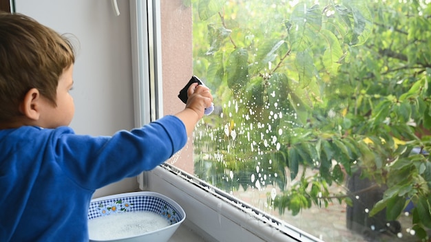 Little child washes the window. High quality photo