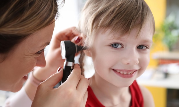 Photo little child with doctor exam hearing deviation