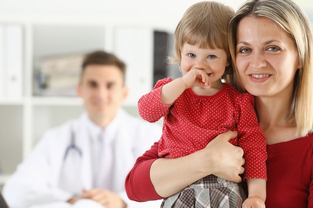 Photo little child with mother at pediatrician