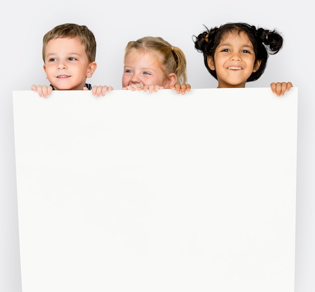 Photo little children holding empty paper smiling