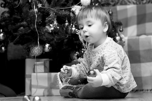 Little children near a Christmas tree before the holidays