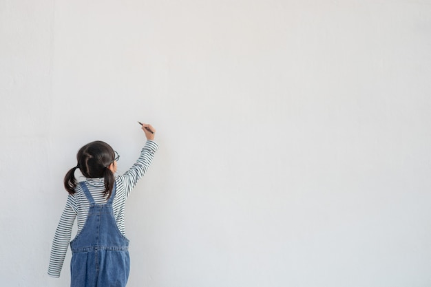 Little children painting on white wall