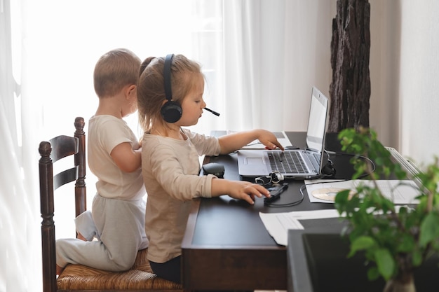 Little children play with computer of parents