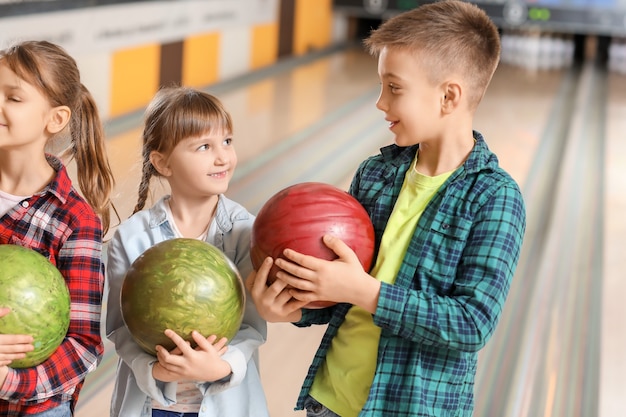 Bambini piccoli che giocano a bowling nel club