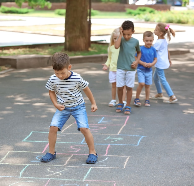 Foto bambini piccoli che giocano a campana, all'aperto