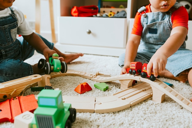 little children playing with a railroad train toy