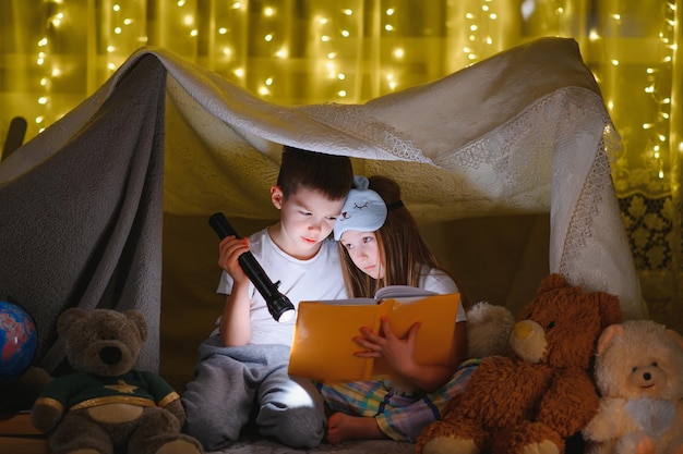 Little children reading bedtime story at home