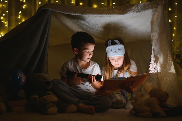 Little children reading bedtime story at home