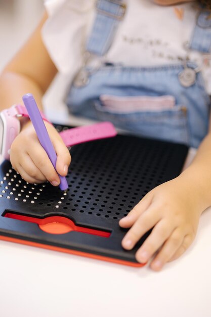 Little children using magnetic pen in kindergarden educational games