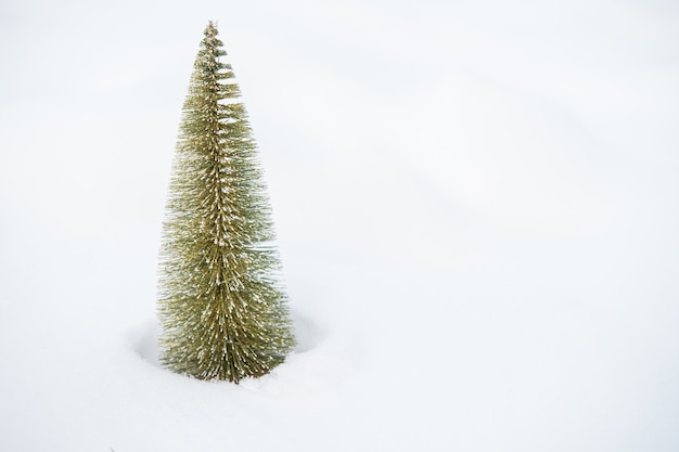 写真 屋外の雪の中で小さなクリスマスツリー。メリークリスマス。あけましておめでとう。高品質の写真