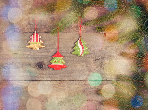 Little Christmas tree toys on pine branch on wood table