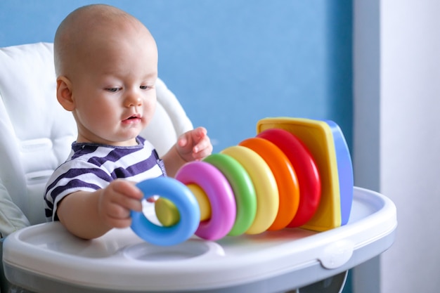 Little clever child playing with colorful plastic toys