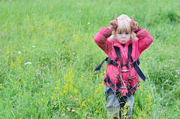 Photo little climber girl in a red jacket in nature