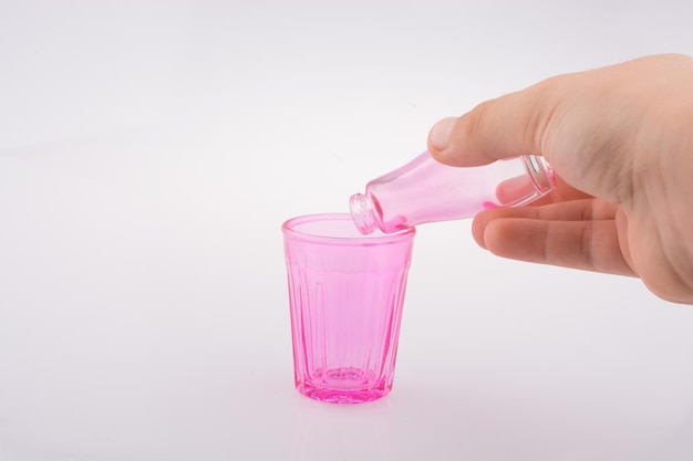 Little colorful bottle over a glass