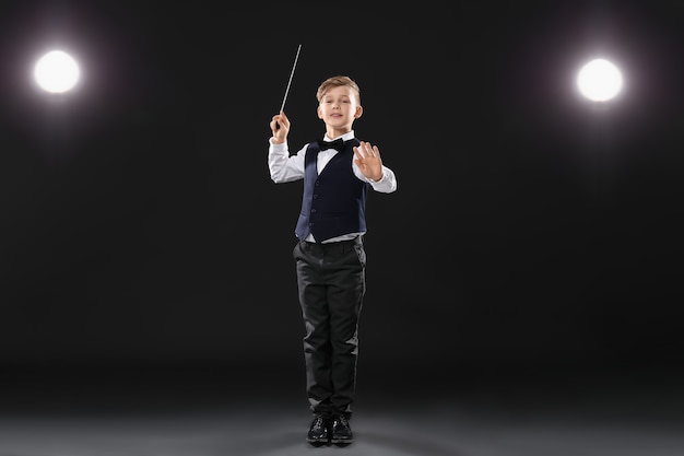 Photo little conductor on dark stage