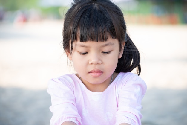 작은 귀여운 아시아 어린이 소녀 검은 긴 머리는 해변에서 놀기를 즐길 수 있습니다. 아이 사람들이 야외 개념.