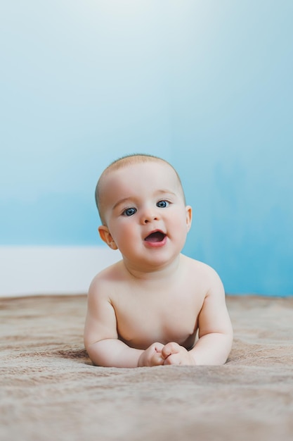 Little cute baby lying on tummy and holding head child development