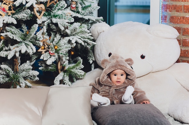 Little cute baby in a suit with bears in the floor.